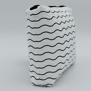 Side view of Small zip pouch in Waving pattern in black and white.