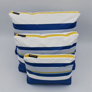 Bundle of three zip pouches in Small, Medium and Large. Lined Up pattern in blue, white and golden yellow.