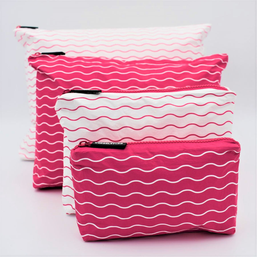 Big bundle of four zip pouches in Mini, Small, Medium and Large. Waving pattern in hot pink and white.