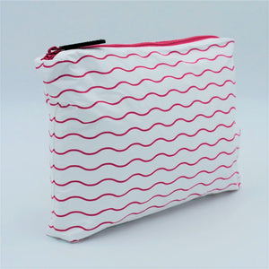 Side view of Small zip pouch in Waving pattern in hot pink and white.