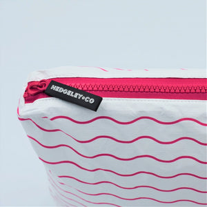 Zip detail of zip pouch in Waving pattern in hot pink and white.