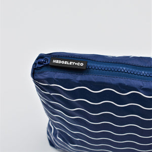 Zip detail of Small zip pouch in Waving pattern in navy blue and white.