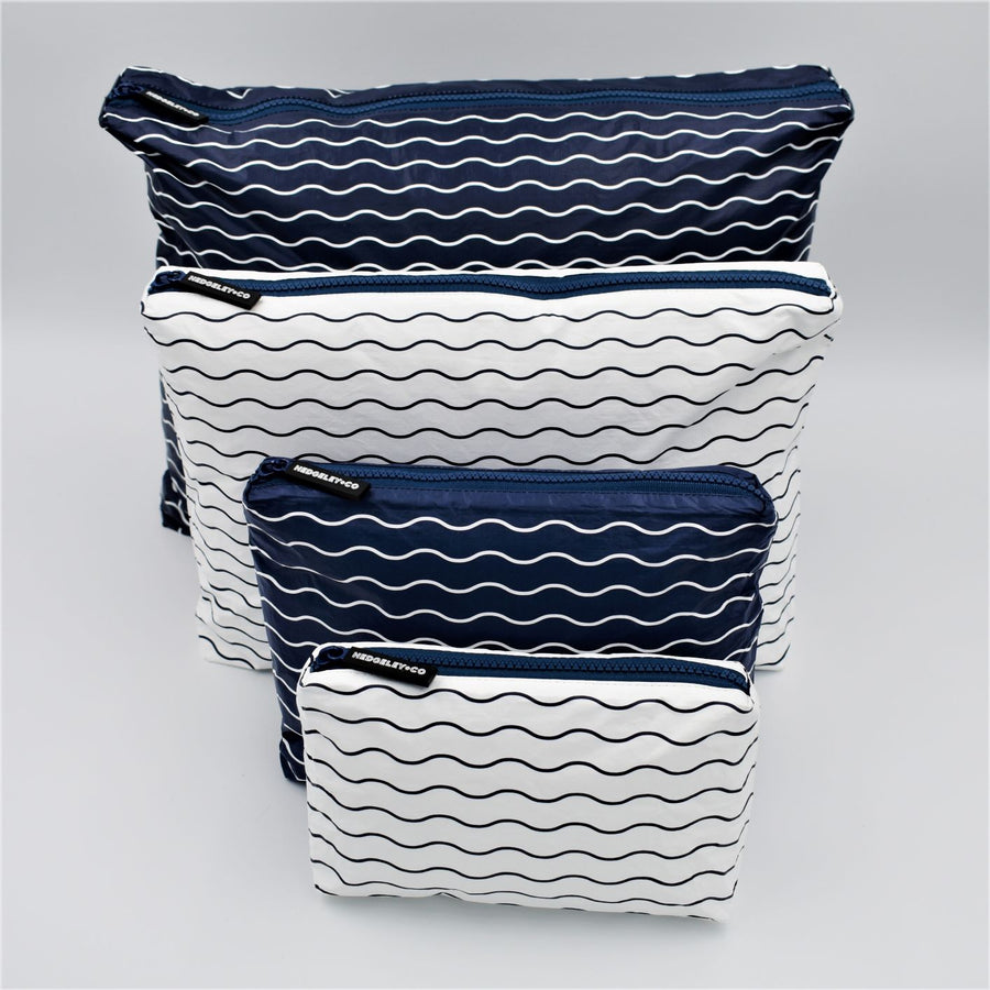 Big bundle of four zip pouches in Mini, Small, Medium and Large. Waving pattern in navy blue and white.