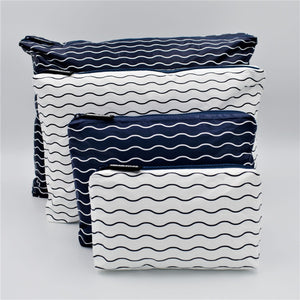 Big bundle of four zip pouches in Mini, Small, Medium and Large. Waving pattern in navy blue and white.