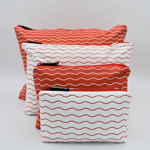 Big bundle of four zip pouches in Mini, Small, Medium and Large. Waving pattern in tomato red and white.