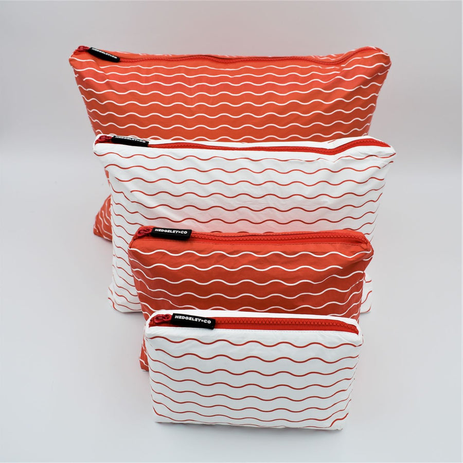 Big bundle of four zip pouches in Mini, Small, Medium and Large. Waving pattern in tomato red and white.