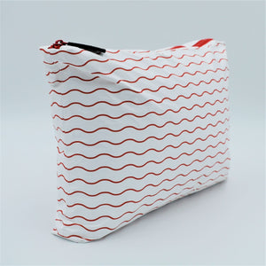 Side view of Medium zip pouch in Waving pattern in tomato red and white.