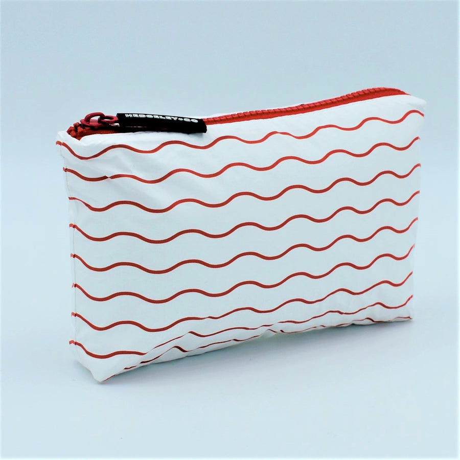 Side view of Mini zip pouch in Waving pattern in tomato red and white.