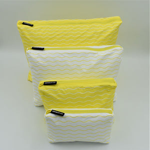 Big bundle of four zip pouches in Mini, Small, Medium and Large. Waving pattern in yellow and white.